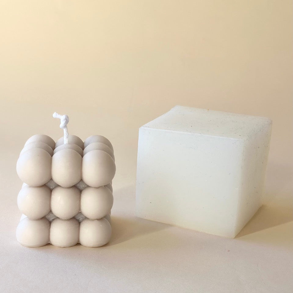 Vela de soja de burbujas con su molde blanco al lado